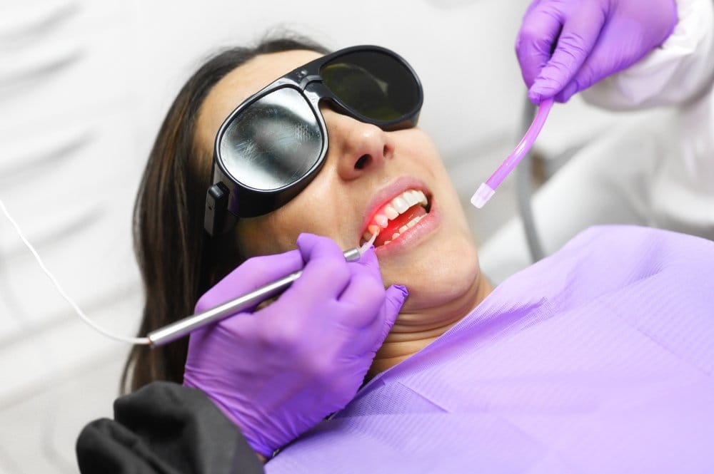 Laser Gum Treatment with Protective Eyewear - Laser Dentistry Patient undergoing laser gum therapy while wearing protective glasses, enhancing gum health and oral hygiene. - Laser Dentistry