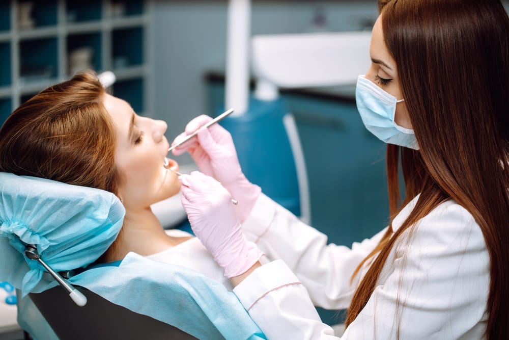 Dentist Performing Professional Dental Examination - Fillings Female dentist conducting a thorough dental checkup for a patient, ensuring healthy teeth and gums. - Fillings